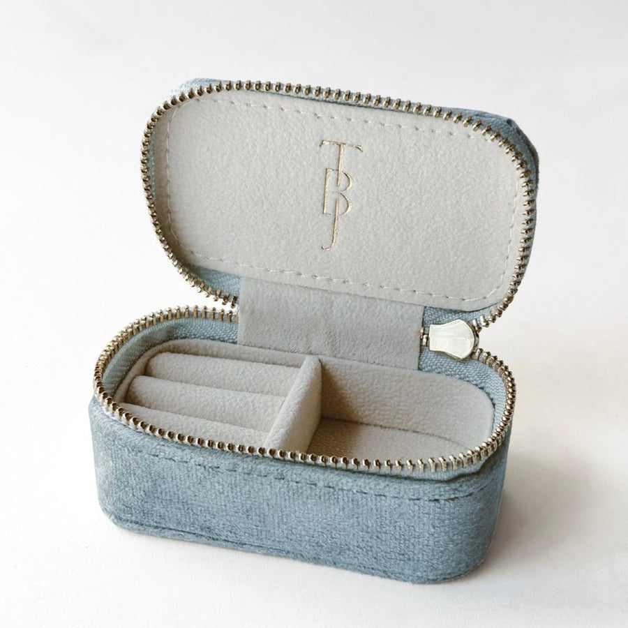 Open blue jewelry box with a ring inside on a white background